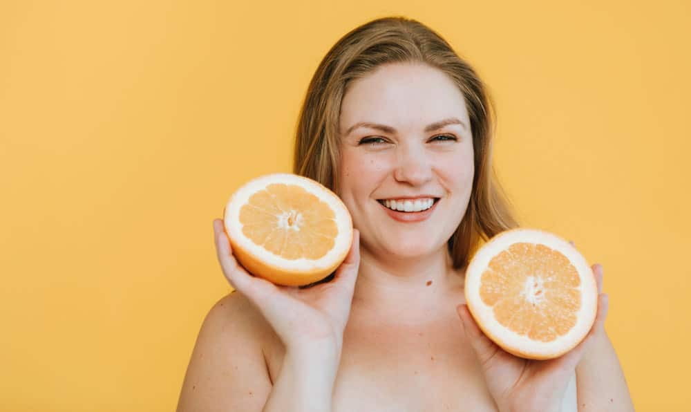 Positive thinking woman eating grapefruits